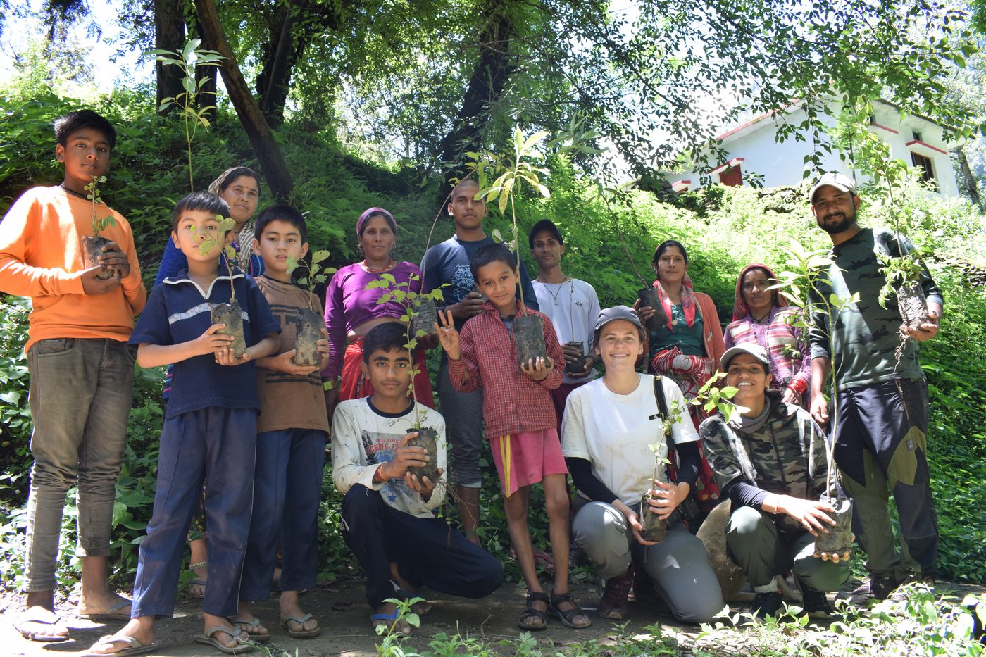 Community members and the project team holding saplings during a plantation activity